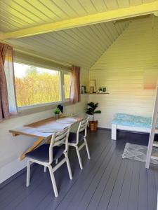 a room with a table and chairs and a window at Diby Kämping Minimajad in Vormsi