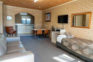 a room with a bed and a table and a kitchen at Sunrise Motel in Barooga