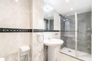 a white bathroom with a sink and a shower at Charming central gem in Poble Sec in Barcelona
