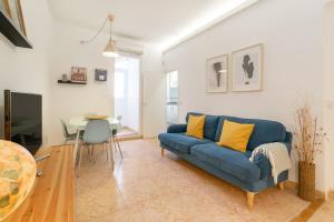a living room with a blue couch and a table at Charming central gem in Poble Sec in Barcelona