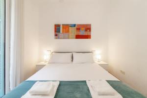 a bedroom with a large white bed with two lamps at Charming central gem in Poble Sec in Barcelona +17 photos