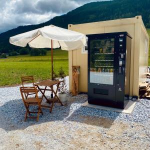 a drink cooler next to a table and an umbrella at Wiesn-Relax-Camping in Ranten