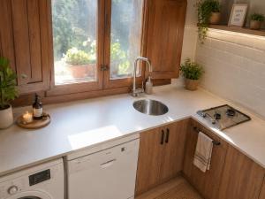a kitchen with a sink and a washing machine at LA CUMBRE-Calma, Desconexión y Piscinas Naturales en Sierra de Gata TR-CC-00490 in Gata
