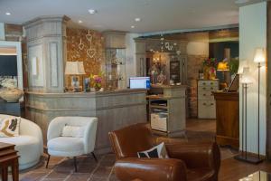 a living room with chairs and a kitchen with a counter at Hôtel le Moulin in Gundershoffen