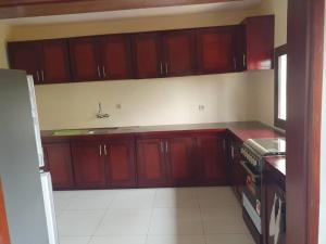 a kitchen with wooden cabinets and a stove top oven at villa HALAL in Mfou