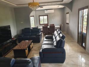 a living room with blue couches and a television at villa HALAL in Mfou