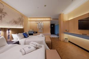 a hotel room with two beds and a television at Hotel Sixty3 in Kota Kinabalu