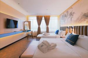 a hotel room with two beds and a flat screen tv at Hotel Sixty3 in Kota Kinabalu