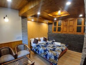 ein Schlafzimmer mit einem Bett und zwei Stühlen in der Unterkunft Annantam in Manali