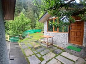 ein Haus mit einem Tisch vor der Tür in der Unterkunft Annantam in Manali