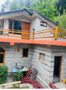 ein Haus mit roten Schüsseln davor in der Unterkunft Annantam in Manali