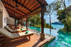 an infinity pool at a villa with a view of the water at Ambong Pool Villas - Private Pool in Pantai Cenang