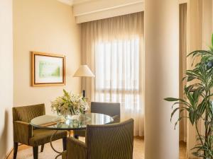 ein Zimmer mit Tisch und Stühlen und einem Fenster in der Unterkunft Mövenpick Hotel Doha in Doha + 97 Fotos