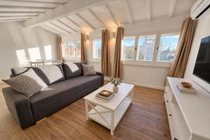 a living room with a couch and a tv at L'Esterel Appartements Plage 450m & Gare Saint-Raphael 950m in Fréjus