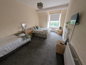 a bedroom with two beds and a tv in it at THE YoRK in Morecambe