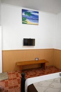 a room with a bed and a tv on the wall at Chika House in Gili Trawangan +20 photos
