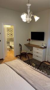 a bedroom with a bed and a tv and a desk at Borgo Caprari in Albinea