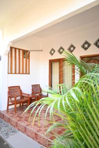a patio of a house with chairs and plants at Chika House in Gili Trawangan