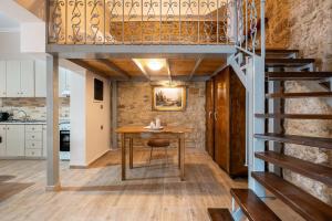 a loft conversions kitchen and dining room with a wooden table and stairs at Absinthia Legacy in Soroni