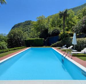 Ein Swimmingpool mit Liegestühlen und einem Berg im Hintergrund in der Unterkunft Villa Maria in Onno