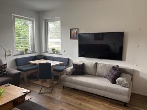 a living room with a couch and a table at Arcana Apartment in Seeboden