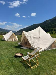 a chair and tents in a field with a table and a grill at Wiesn-Relax-Camping in Ranten