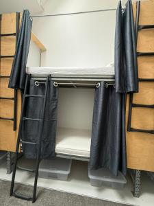 a room with a bunk bed with black curtains at The Old Factory in Copenhagen +7 photos