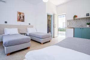 a bedroom with two beds and a couch and a chair at Seaside Resorts in Kavos