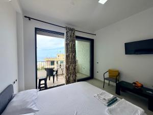 a bedroom with a bed and a large window at Actium in Vlorë