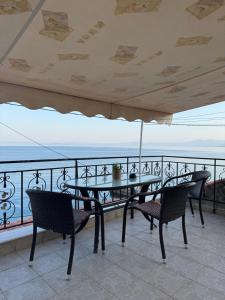 a table and chairs on a balcony with a view of the ocean at Stella Studios in Ilia