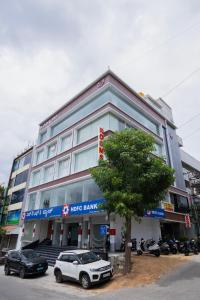 a large building with cars parked in front of it at Sri Sai Lotus In in Bangalore