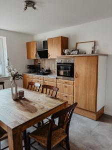 a kitchen with wooden cabinets and a wooden table with chairs at Ankerplatz in Leer