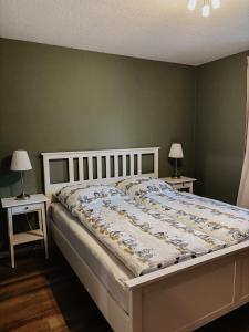 a bedroom with a bed with two night stands and two lamps at Ankerplatz in Leer