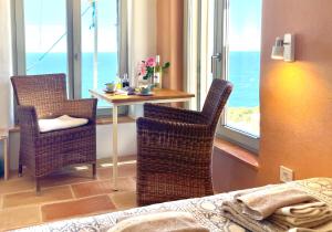 a room with a table and two chairs and a bed at Unique Robinson-House with breathtaking seaview in Podšpilje