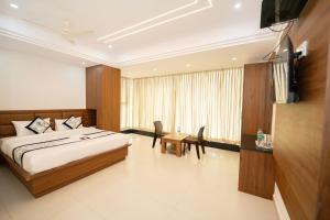 a bedroom with a bed and a television in it at Sri Sai Lotus In in Bangalore