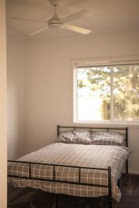 a bedroom with a bed with a ceiling fan at Agnes homestead in Welshpool