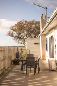 a patio with a table and chairs and a fence at Agnes homestead in Welshpool