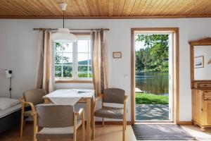 a dining room with a table and chairs and a window at Kanalvillan Dalsland in Dals Långed