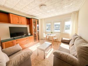 a living room with a couch and a tv and a table at Apartamento Brisa by ALÔGA in Corcubión
