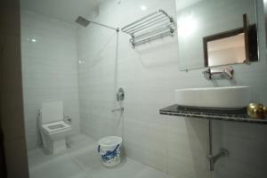 a white bathroom with a sink and a toilet at Hotel Parkview in Khajurāho +6 photos