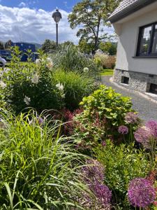 a garden with flowers and plants in front of a house at Ferienhaus AhrIdylle in Bad Neuenahr-Ahrweiler