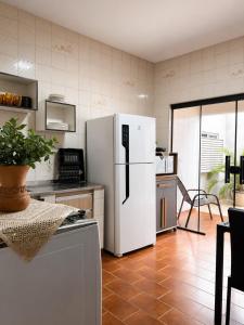 a kitchen with a white refrigerator and a table at Casa Temporada Espaço Vip in Barra do Garças
