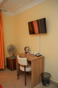 a desk with a chair and a television on a wall at Grand Forty Garden Ltd in Kisumu