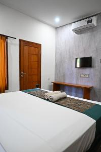a bedroom with a bed with two towels on it at Chika House in Gili Trawangan