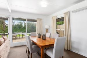 a dining room with a wooden table and chairs at Fennell House in Robe