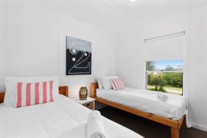 a bedroom with two beds and a window at Fennell House in Robe
