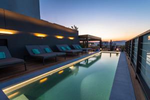 a hotel swimming pool with couches and a building at The Duke Boutique Suites in Athens
