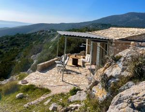 a house with a table and chairs on a mountain at Unique Robinson-House with breathtaking seaview in Podšpilje