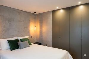 a bedroom with a large white bed with green pillows at Fisherman's View in Aveiro
