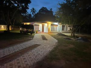 a house with a car parked in front of it at The Highland Manor in Weligama